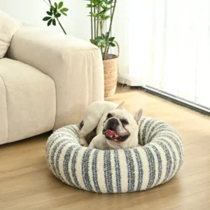 Small cat dog resting in soft striped donut pet bed, XS round cushion.